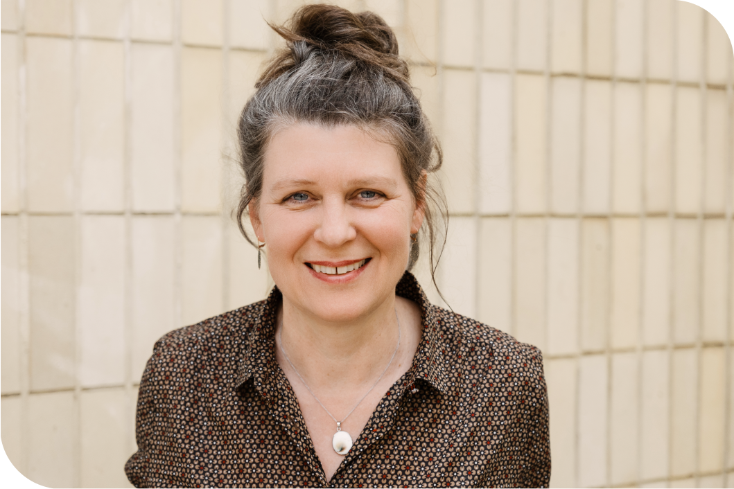 Portrait von Marlies Heidle vor einer Fliesenwand